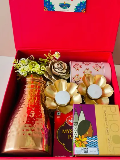 A closer look inside the red gift box, highlighting the beautiful golden flower t-light holders and the premium Phool incense.