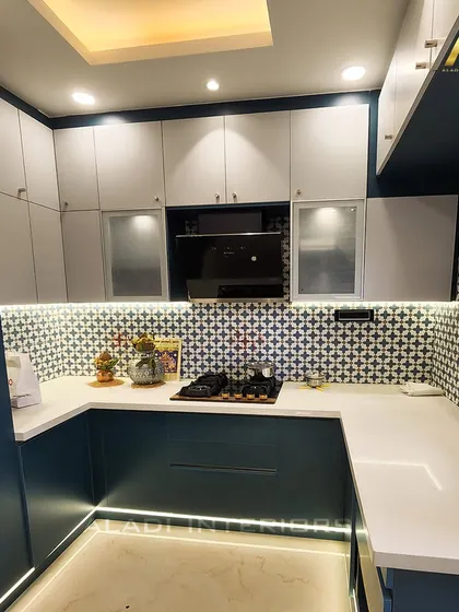 A stylish kitchen with a bold blue and white color scheme. The patterned backsplash adds a decorative element, while under-cabinet lighting ensures a well-lit prep area.