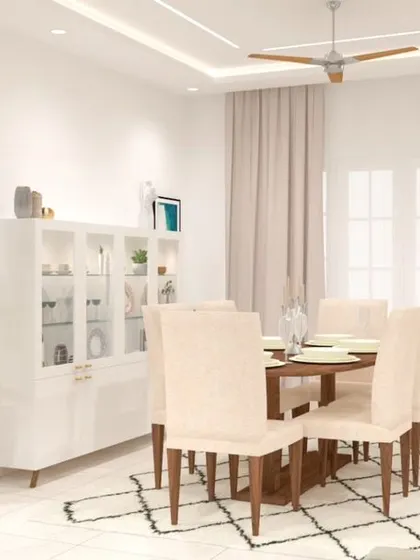 This clean and minimalist dining room uses a white and wood theme, with a classic six-seater table and a matching white crockery unit. The geometric rug adds a touch of modern pattern to the floor.