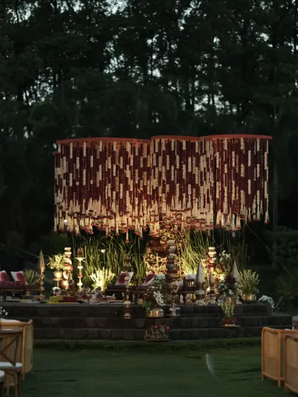 A wider perspective of the Banaras Ghat themed mandap, showing its impressive scale against the evening sky. The design creates an intimate yet grand space for the wedding rituals.