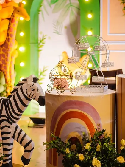 A close-up of the boho-themed decor, featuring a miniature zebra, a golden ferris wheel, and a rainbow-painted cake stand. The mix of textures and elements creates a rich, bohemian vibe.