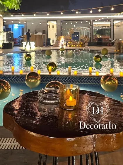 A close-up of a high-top table by the pool, showing how even small details like a single candle can contribute to the overall elegant and relaxed party atmosphere.