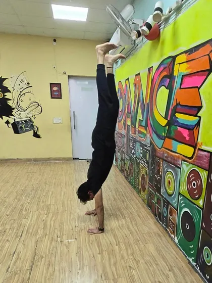The studio is my playground for pushing limits. This handstand against the wall shows how the space is perfect for everything from dance to advanced calisthenics.