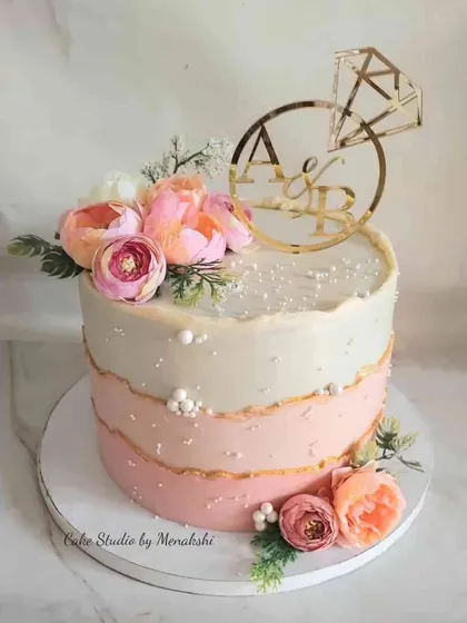 This single-tier engagement cake features a lovely pink ombre effect and is completely free of fondant. It's adorned with fresh flowers and a custom initial topper, making it perfect for a small, personal celebration.