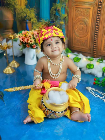 A beautiful, smiling portrait of our little Kanha. The lighting is designed to create a soft, divine glow, highlighting his innocent features.