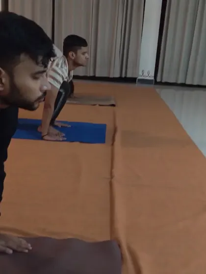 Participants in a forward bend, a posture that brings flexibility to the spine and calmness to the mind.
