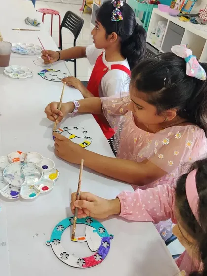 A group of girls painting their Diwali hangings at a birthday party. It's fun to combine celebrations with seasonal crafts.