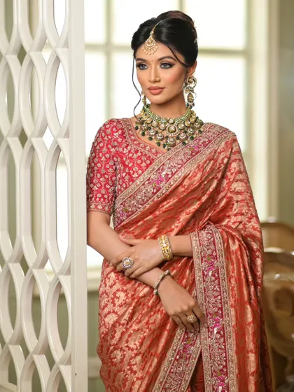 The rich red blouse pairs perfectly with the rust-colored saree. The drape is clean and allows for easy movement.