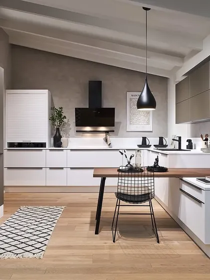 This design pairs crisp white lower cabinets with greige upper cabinets and a wood dining extension, creating a light and airy space with a touch of Scandinavian warmth.