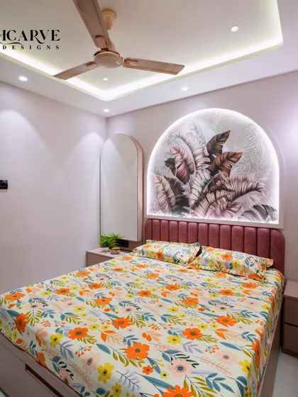 Another angle of the pink bedroom, showing the arched mirror that complements the headboard design.