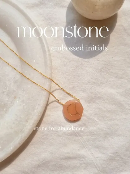 My initial embossed antique-style pendant on a pebble-shaped Peach Moonstone. This stone attracts abundance and good fortune in love.