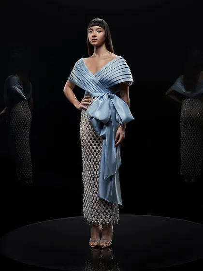 A full-length shot of an icy blue dress by Alpana Neeraj, set against a black background to emphasize its form.