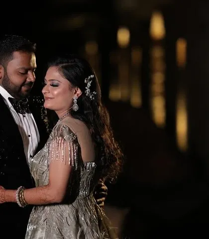 An intimate portrait from a glamorous reception. The bokeh from the background lights adds a magical feel as the couple shares a quiet moment together, lost in their own world.