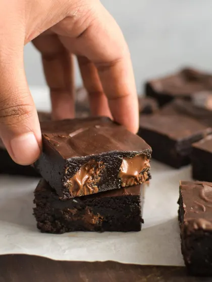A stack of my gooey fudgy chocolate chip brownies. The melted chocolate chunks inside create pockets of molten goodness, making them incredibly decadent.