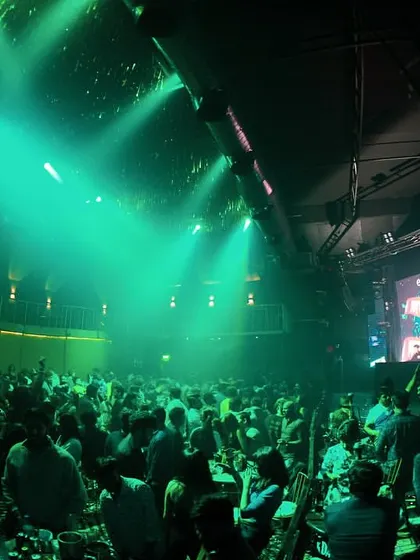 The club is glowing green as the beat drops. I work with the lighting team to create a dynamic and visually stunning show.