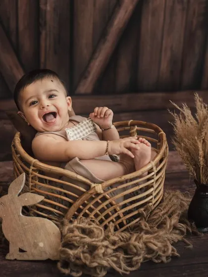 A big, hearty laugh from this little one in our rustic studio setup. Capturing genuine happiness is our main goal.