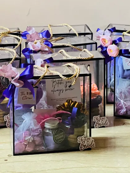 A collection of my popular bridesmaid proposal hampers. The clear acrylic boxes showcase the curated items inside, including candles, cookies, and personalized notes, all tied with beautiful ribbons.