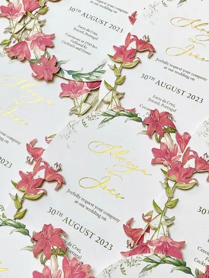 A pattern of the die-cut floral invitations. The repetition highlights the incredible detail of the 3D flowers and the elegance of the gold foil script.