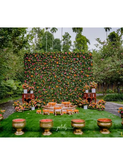 For this Haldi, I created a lush flower wall as the backdrop. The vibrant mix of colorful flowers and traditional brass urlis filled with petals makes for a stunning and photogenic setting.