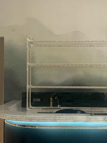 A custom curved bar with fluted detailing and a watercolor-effect wall finish. This is one of those special details that will make a space unique.