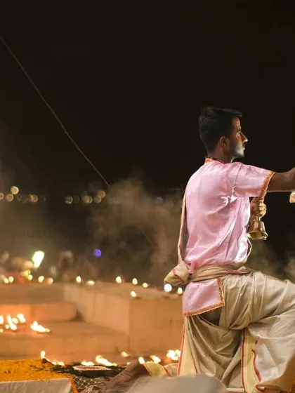 A wide-angle view of the Ganga Aarti, showing multiple priests performing the ritual in unison. This highlights the scale and coordination of the grand ceremony.
