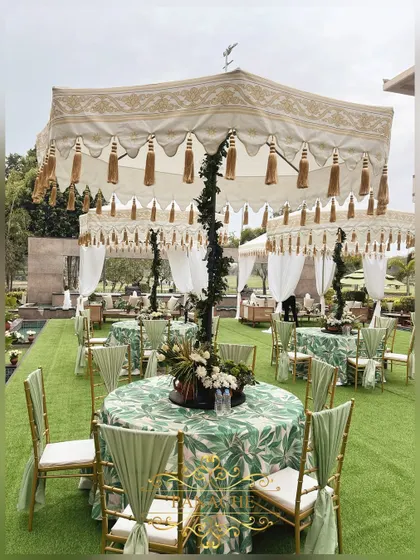 A view of the guest seating, with tables covered in a green leaf-print linen and topped with elegant umbrellas.