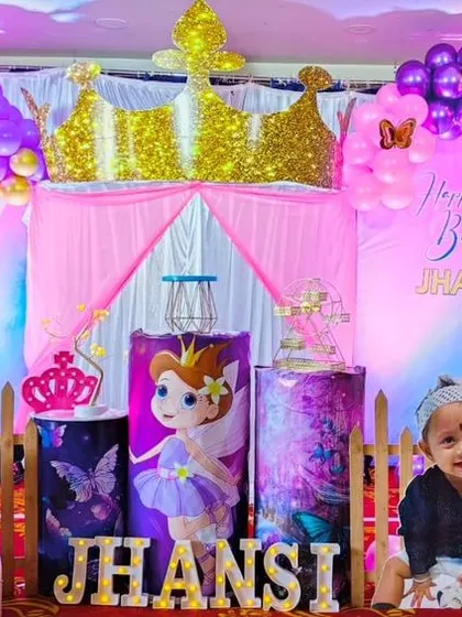 A royal celebration for a little princess. This fairy princess theme for Jhansi's first birthday includes a golden crown, character cutouts, and a pink and purple color palette.