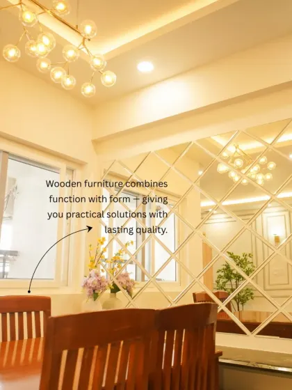 A dining area featuring a mirrored wall with a diamond pattern that visually expands the space. The modern chandelier and classic wooden dining chairs create a beautiful contrast.