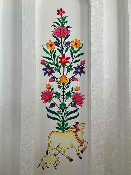 A detailed view of the central panel, featuring the holy cow and calf beneath a vibrant 'tree of life' design.