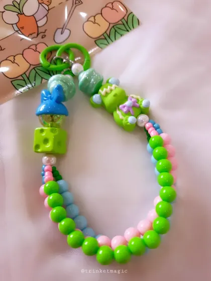 A vibrant, multi-colored beaded charm in shades of green, blue, and pink. This one has a fun, almost tropical vibe with its bright colors and unique bead shapes.