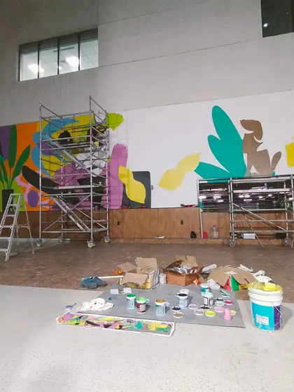 The worksite of the Hyderabad mural, with paints, tools, and scaffolding ready for a day of creation.