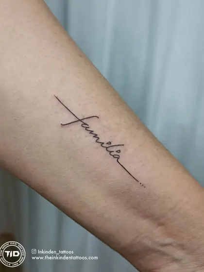 A clean, crisp, single-line script tattoo of the word "Familia." This elegant design is a timeless tribute to the importance of family.