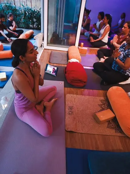 A moment of gratitude and connection during a full class. You can see both our indoor studio and the outdoor patio filled with students, all sharing the same energy.