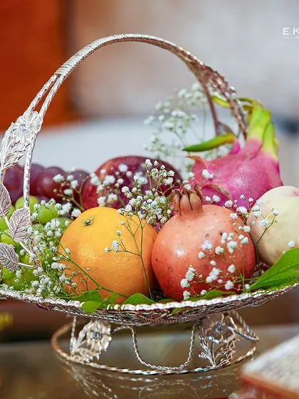 An elegantly designed silver fruit platter, overflowing with fresh produce. This piece adds a touch of sophisticated abundance to wedding celebrations and festive decor, serving as a beautiful and practical centerpiece.