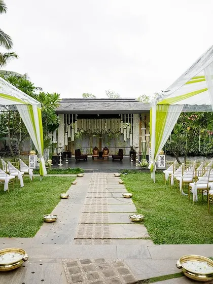 Elegant guest seating under a transparent rainproof tent. This practical solution ensures guest comfort without obscuring the beauty of the venue, with the green and white drapes adding a touch of color.