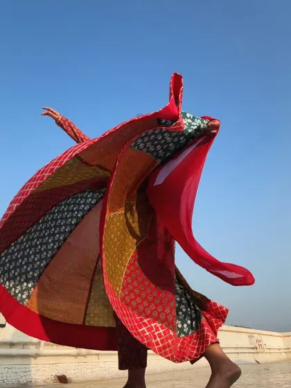 The costume itself becomes a dynamic part of the dance in this photo, as the fabric flies up in a spectacular display of color and movement.