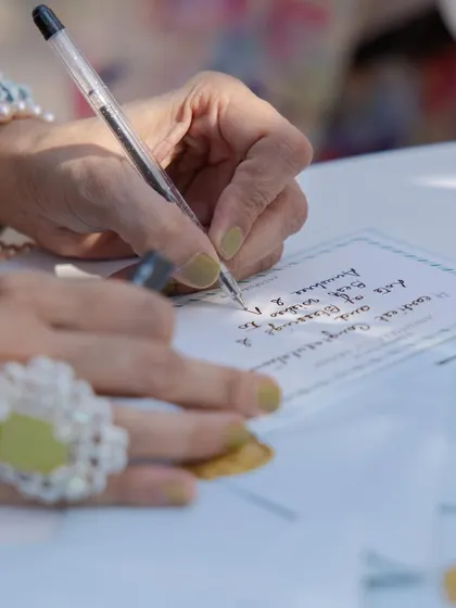 A guest pens a heartfelt message for the couple. We create dedicated spaces and beautiful stationery for guests to leave their blessings and well wishes.