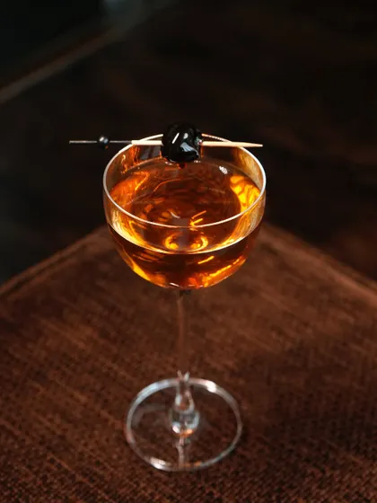A closer look at our Forest cocktail, where aged whisky meets the unexpected notes of pinewood tea and green apple. Garnished with a single dark cherry, it is a sophisticated drink for the discerning palate.