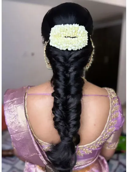A thick, glossy fishtail braid with a rectangular jasmine gajra, showcasing a clean and polished finish.
