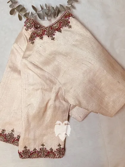 A side view of the off-white blouse, showing the detailed borders.