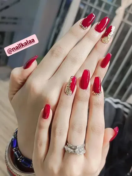 A bold and glamorous red set on long square nails. The accent nails feature a textured gold glitter design for a touch of luxury.