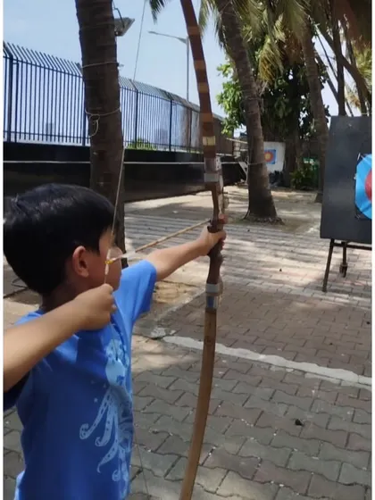A young boy at our Dadar range, concentrating hard before his shot. This outdoor setting with palm trees is one of our most popular locations.