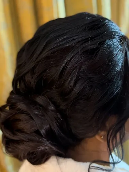 Another view of the soft, textured updo, showing the gentle waves and pinned curls that create this romantic look.