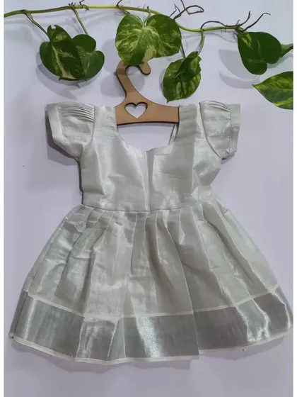 Just in time for Onam, this silver tissue dress is a delicate and beautiful piece. It has a soft cotton lining that gets softer with every wash and a little bow detail at the back.