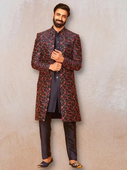 For a bold and memorable look, this dark sherwani with vibrant red floral embroidery is a fantastic choice. It's perfect for an evening reception or sangeet.