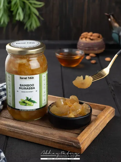 Dark, moody lighting gives this shot of Bamboo Murabba a premium and sophisticated feel. The focus is on the unique texture of the product, both in the jar and on the fork.