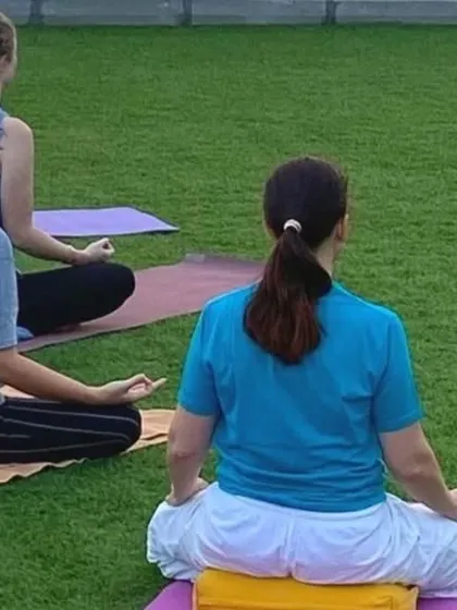 Students practicing meditation on the grass during a yoga retreat in Dubai. We adapt our practice to different environments, always focusing on the inner experience.