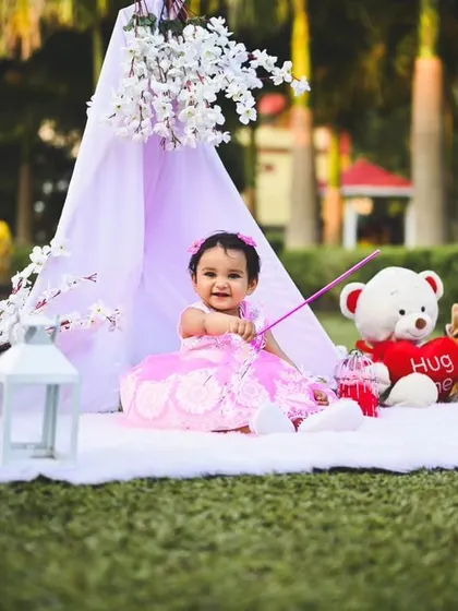 A happy, interactive moment as the birthday girl plays with a wand in her beautifully decorated outdoor setting.