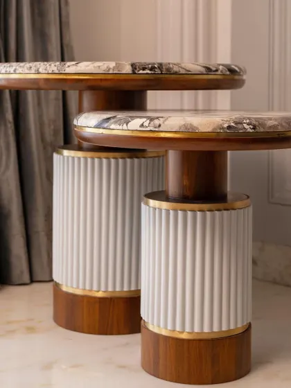 Another view of the custom side tables, showing their sculptural form and elegant material combination.
