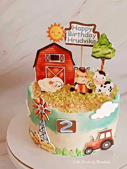 A super cute farm themed cake for a toddler's second birthday. This design features a red barn, a windmill, and adorable farm animals like a cow, sheep, and horse.
